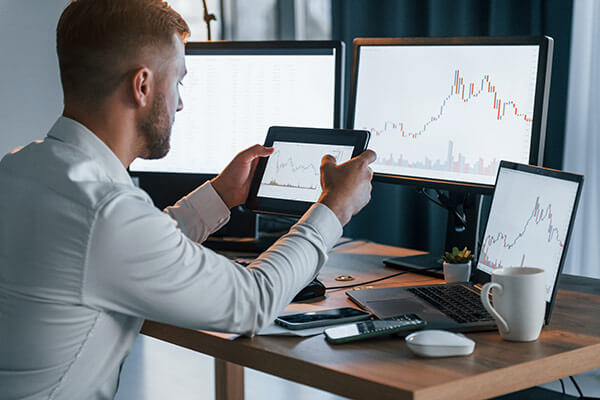 Man using tablet to look at graph chart